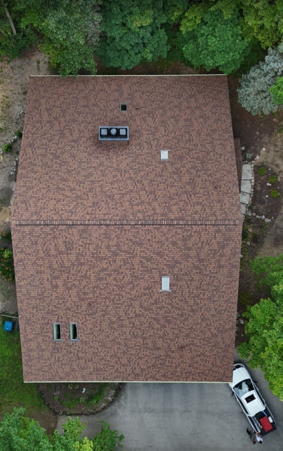 Overhead drone view of a completed brown architectural shingle roof with skylights and roof vents. Roofing work by Alba Pro Construction serving Hackensack, NJ.