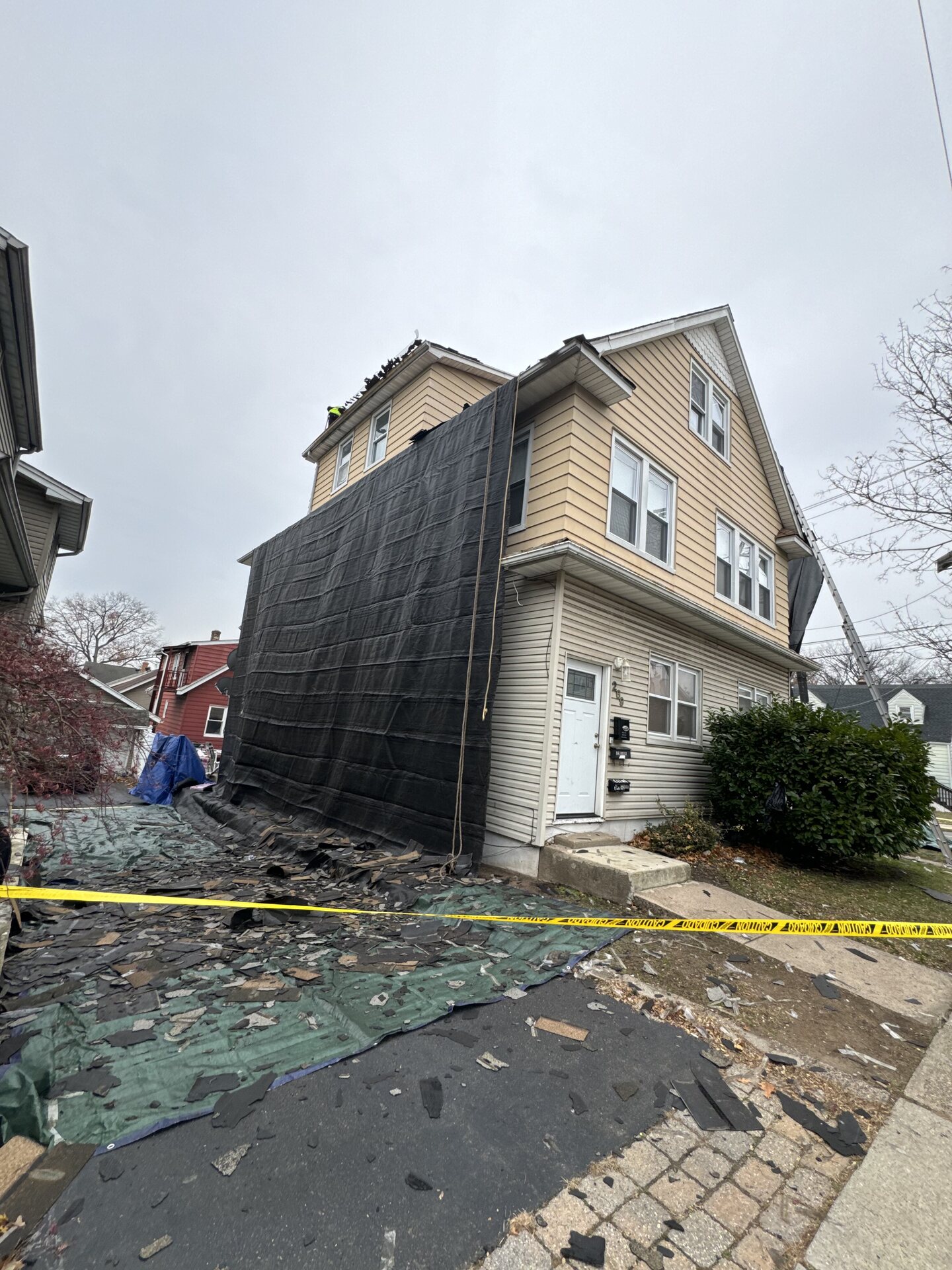 New Jersey home protected with debris netting during a roof replacement. Roofing work by Alba Pro Construction serving Elizabeth, NJ.