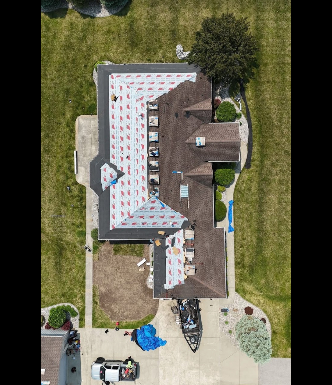 Aerial view of a roof replacement in progress with synthetic underlayment installed and shingle bundles staged across the slopes. Roofing work by Alba Pro Construction serving Totowa, NJ.