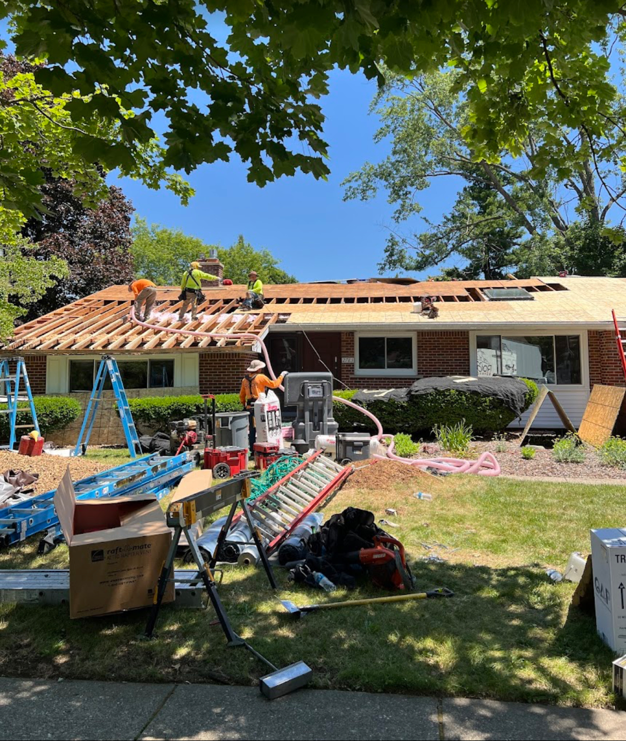Roofing crew rebuilding the deck on a brick ranch with new sheathing, ridge vent and tools staged in the front yard. Roofing work by Alba Pro Construction serving River Edge, NJ.