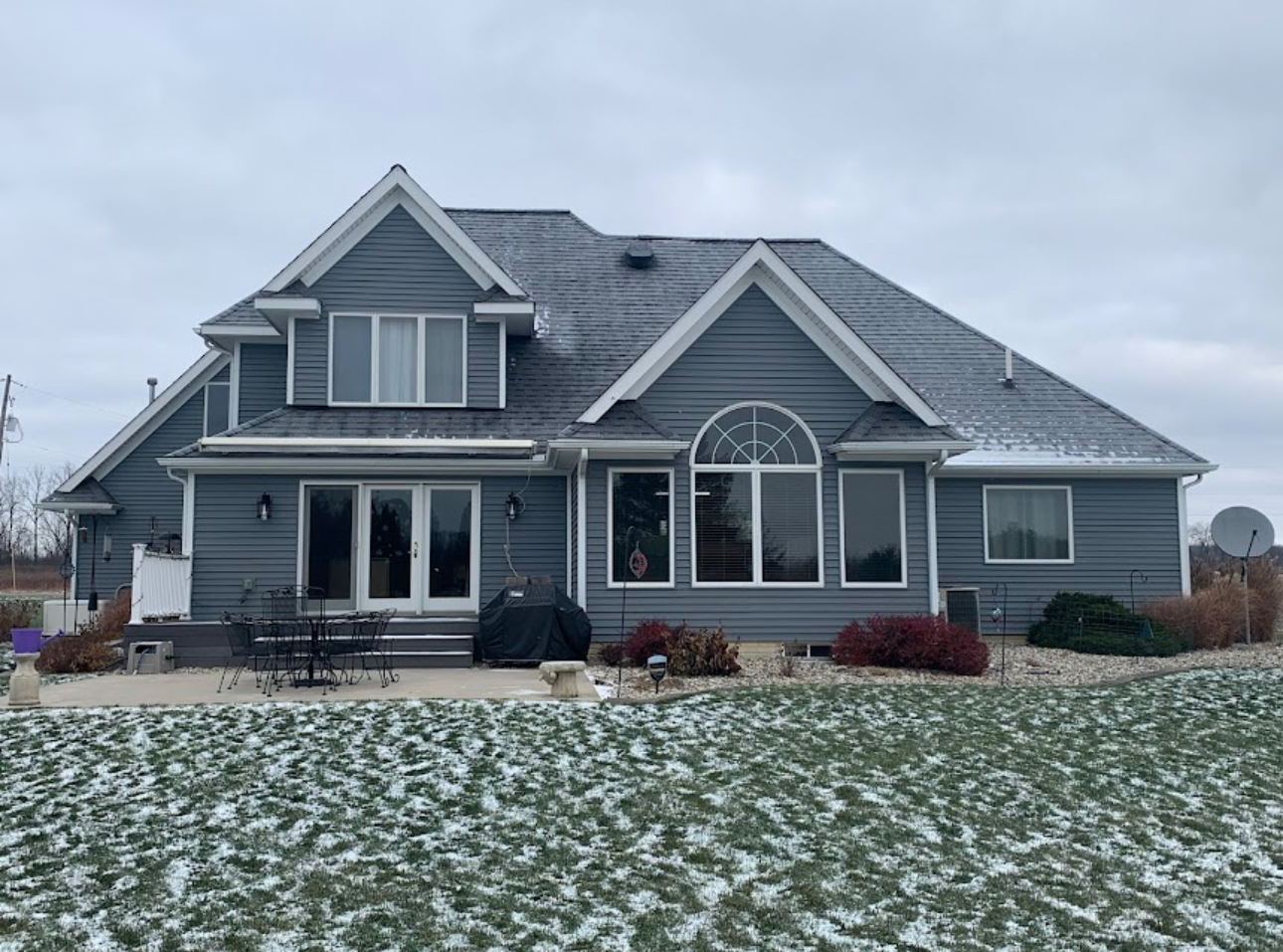 Grey home with a completed architectural shingle roof photographed after a light winter snow. Roofing work by Alba Pro Construction serving Tenafly, NJ.