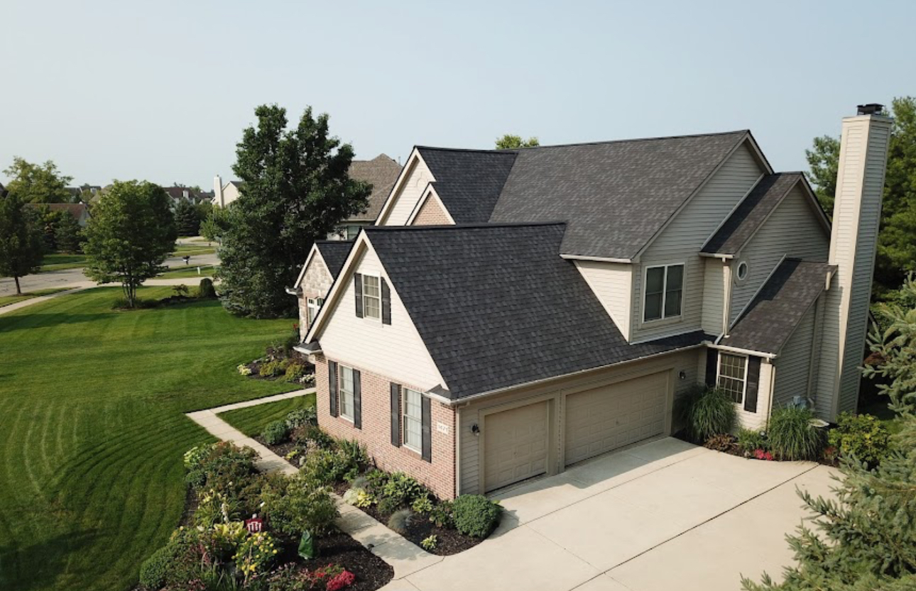 Two-story home with a completed dark charcoal architectural shingle roof and clean valley lines. Roofing work by Alba Pro Construction serving Hackensack, NJ.